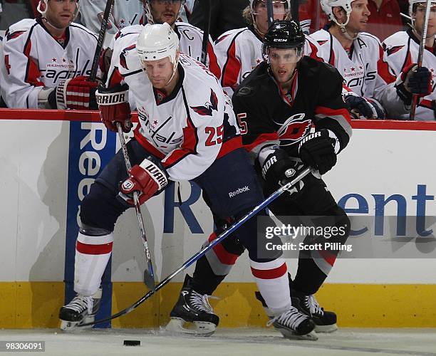 Alexandre Picard of the Carolina Hurricanes battles for the puck with Jason Chimera of the Washington Capitals during their NHL game on March 25,...