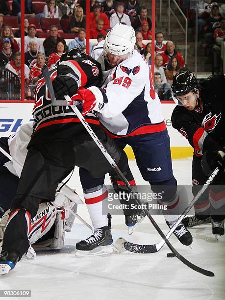 Tyler Sloan of the Washington Capitals keeps Erik Cole of the Carolina Hurricanes away from his goalie during their NHL game on March 25, 2010 at the...