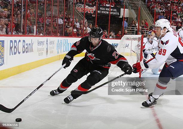 Erik Cole of the Carolina Hurricanes looks to keep Tyler Sloan of the Washington Capitals off the puck during their NHL game on March 25, 2010 at the...