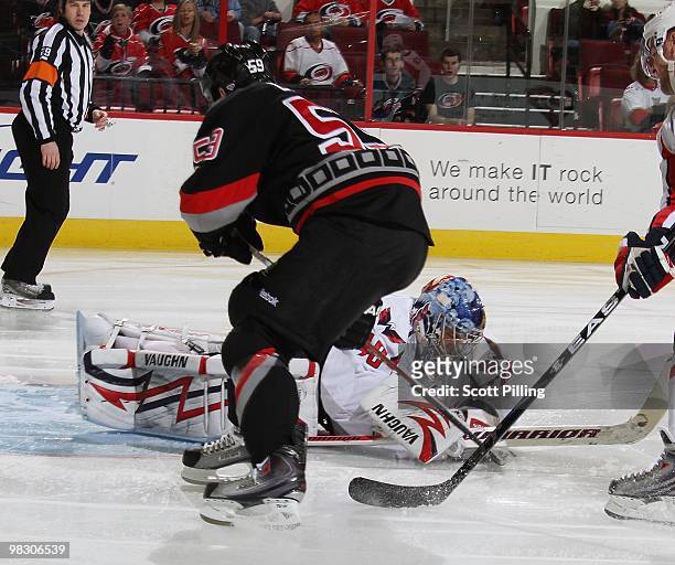 Seymon Varlamov of the Washington Capitals dives onto the puck to keep Chad LaRose of the Carolina Hurricanes from scoring during their NHL game on...
