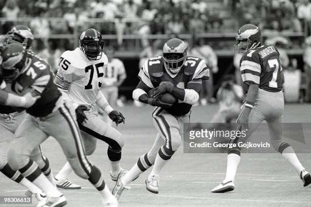 Running back Wilbert Montgomery of the Philadelphia Eagles runs behind the blocking of offensive lineman Stan Walters after taking a handoff from...
