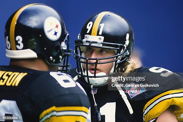 Linebacker Kevin Greene of the Pittsburgh Steelers talks with center Dermontti Dawson during a National Football League game against the Miami...
