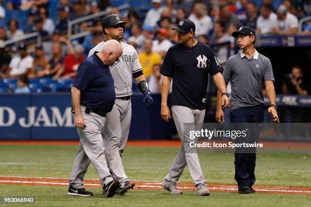 New York Yankees catcher Gary Sanchez walks off the field with New York Yankees manager Aaron Boone , Trainer Steve Donohue and Yankees Spanish...