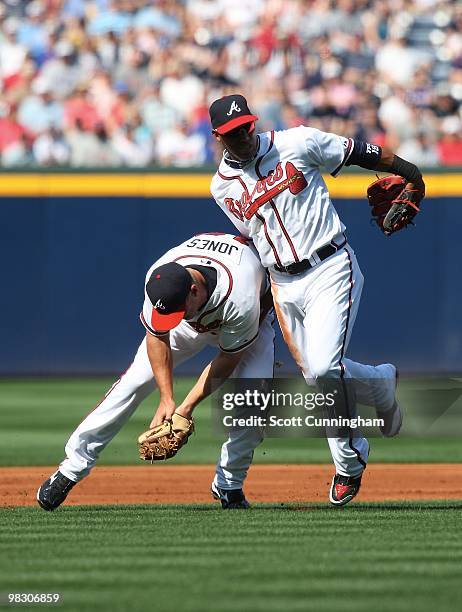 Chipper Jones and Yunel Escobar of the Atlanta Braves collide while fielding a grounder against the Chicago Cubs during Opening Day at Turner Field...