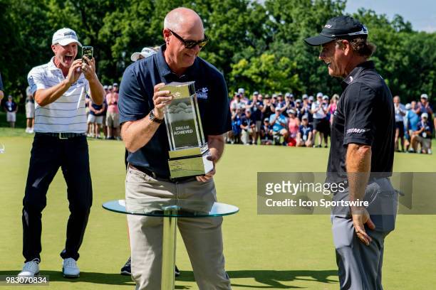 American Family Mutual Insurance Chair and CEO Jack Salwedel presents tournament champion Scott McCarron with the trophy as Steve Stricker record on...