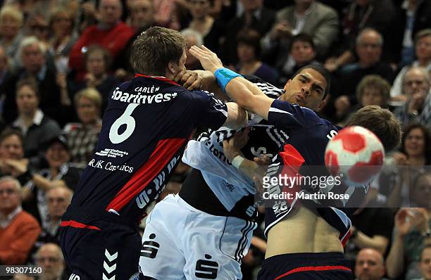 Daniel Narcisse of Kiel challenges Lasse Hansen and Oscar Carlen of Flensburg-Handewitt for the ball during the Toyota Handball Bundesliga match...
