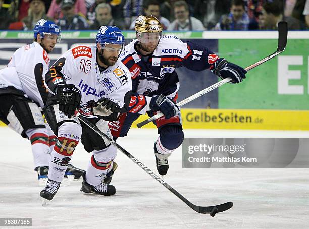 Tyler Beechey of Augsburg battles for the puck with Sven Felski of Berlin during the fifth DEL quarter final play-off game between Eisbaeren Berlin...