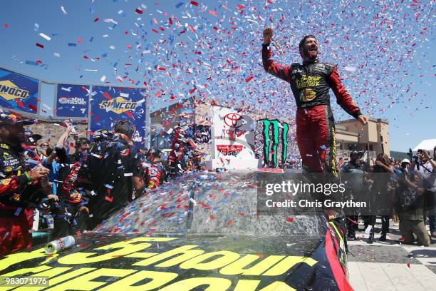 Martin Truex Jr., driver of the 5-hour ENERGY/Bass Pro Shops Toyota, celebrates in victory lane after winning the Monster Energy NASCAR Cup Series...