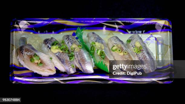 horse mackerel sushi in disposable plastic tray on black background - trachurus trachurus stockfoto's en -beelden