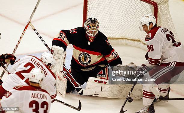 Antti Niemi of the Chicago Blackhawks stops a shot by Lee Stempniak of the Phoenix Coyotes as Vernon Fiddler slaps at the puck at the United Center...