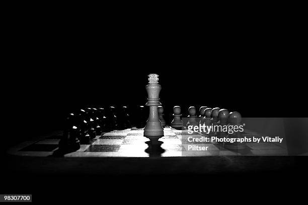 chess pawns surrounding the king  - sunnyside photos et images de collection