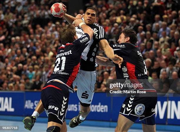 Daniel Narcisse of Kiel challenges Jacob Heinl and Tobias Karlsson of Flensburg-Handewitt for the ball during the Toyota Handball Bundesliga match...