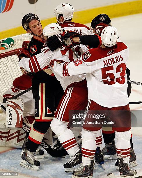 Jonathan Toews of the Chicago Blackhawks gets into a shoving match with Petteri Nokelainen and Derek Morris of the Phoenix Coyotes in front of the...