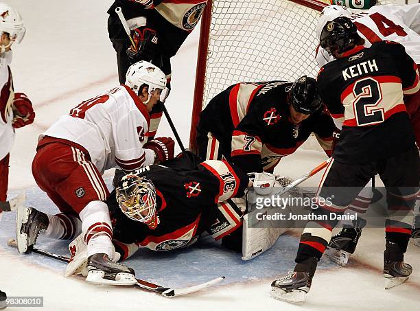 Antti Niemi of the Chicago Blackhawks falls on the puck as Shane Doan of the Phoenix Coyotes collides with him while Brent Seabrook and Duncan Keith...
