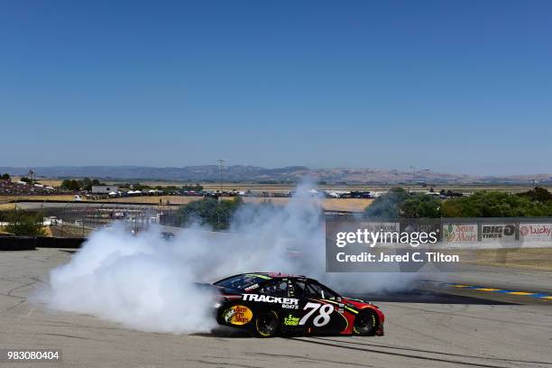 Martin Truex Jr., driver of the 5-hour ENERGY/Bass Pro Shops Toyota, celebrates with a burnout after winning the Monster Energy NASCAR Cup Series...