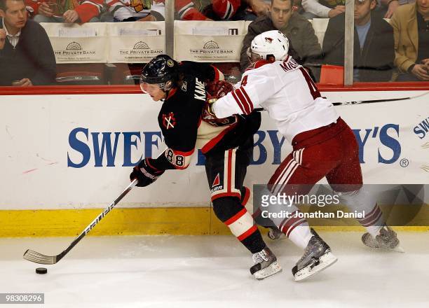 Patrick Kane of the Chicago Blackhawks is pushed in the back by Zbynek Michalek of the Phoenix Coyotes at the United Center on March 23, 2010 in...