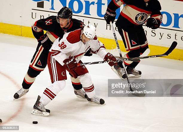 Vernon Fiddler of the Phoenix Coyotes battles for the puck with Jonathan Toews of the Chicago Blackhawks at the United Center on March 23, 2010 in...