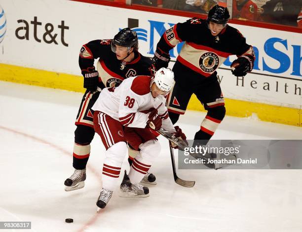 Vernon Fiddler of the Phoenix Coyotes battles for the puck with Jonathan Toews and Patrick Kane of the Chicago Blackhawks at the United Center on...