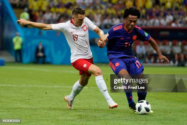 Piotr Zielinski of Poland struggles with his competitor Juan Cuadrado of Colombia during the 2018 FIFA World Cup Russia Group H match between Poland...