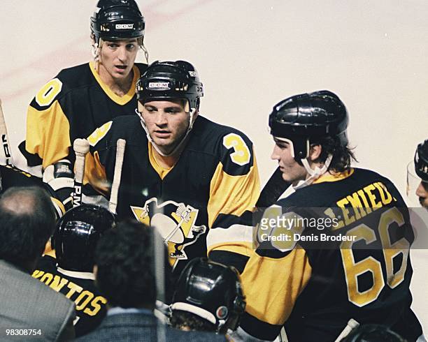 Mario Lemieux of the Pittsburgh Penguins stands at the players bench ready for direction from his coach in the game against the Montreal Canadiens in...