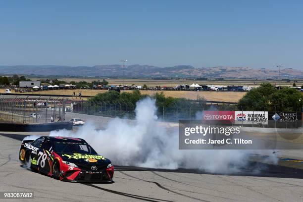 Martin Truex Jr., driver of the 5-hour ENERGY/Bass Pro Shops Toyota, celebrates with a burnout after winning the Monster Energy NASCAR Cup Series...