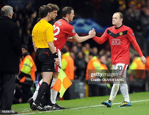 Manchester United's English forward Wayne Rooney is substituted by Manchester United's Irish player John O'Shea during the UEFA Champions League...