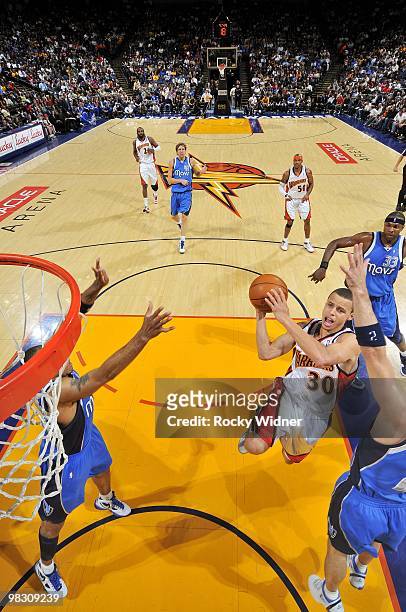 Stephen Curry of the Golden State Warriors goes up for a shot against Shawn Marion and Jason Kidd of the Dallas Mavericks during the game at Oracle...