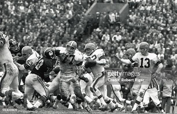 Dick Schafrath of the Cleveland Browns blocks for Jim Brown as Frank Ryan looks on during a circa 1960s game against the Pittsburgh Steelers.
