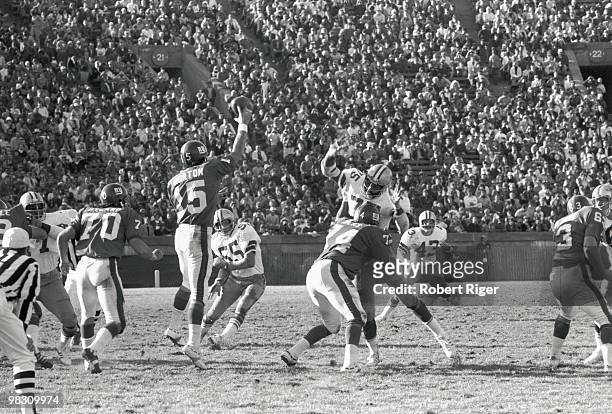 Craig Morton of the New York Giants passes as Bob Hyland and John Hicks block as Lee Roy Jordan, Jethro Pugh and Cliff Harris of the Dallas Cowboys...