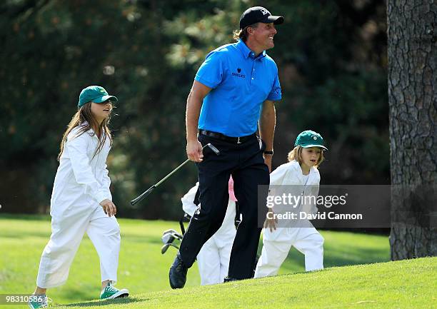 Phil Mickelson walks with his caddies/children Amanda, Sophia and Evan during the Par 3 Contest prior to the 2010 Masters Tournament at Augusta...