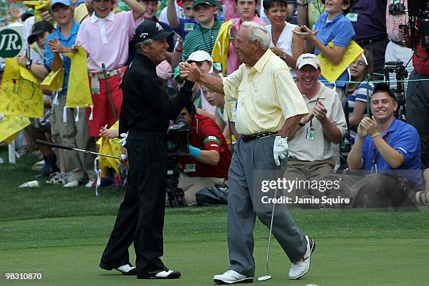 Gary Player congratulates Arnold Palmer on sinking a long birdie putt during the Par 3 Contest prior to the 2010 Masters Tournament at Augusta...