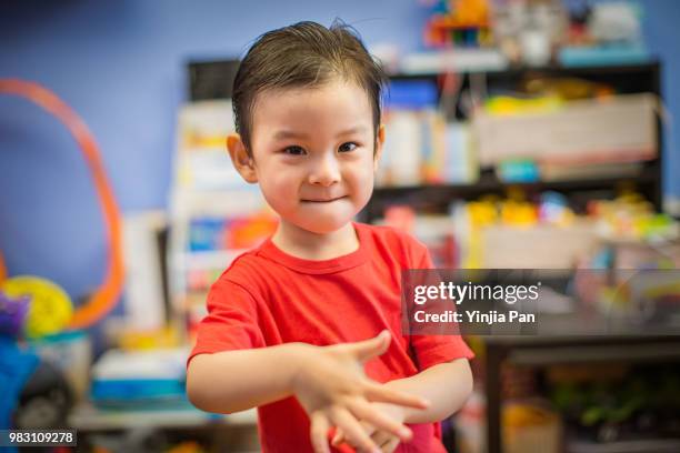 portrait of a baby boy making time out gesture and looking at camera at home - señal de juego fotografías e imágenes de stock