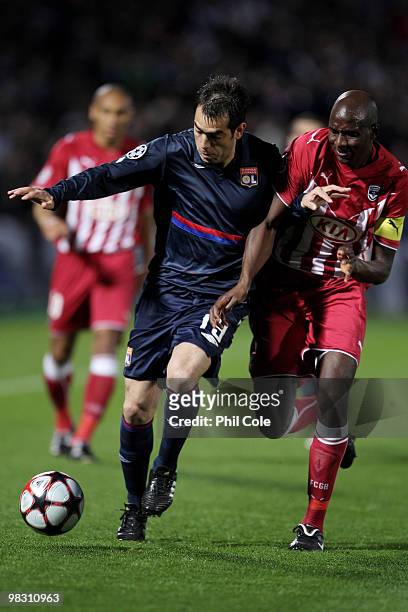 Cesar Delgado of Olympique Lyonnais is challenged by Alou Diarra of Bordeaux during the UEFA Champions League quarter final second leg match between...