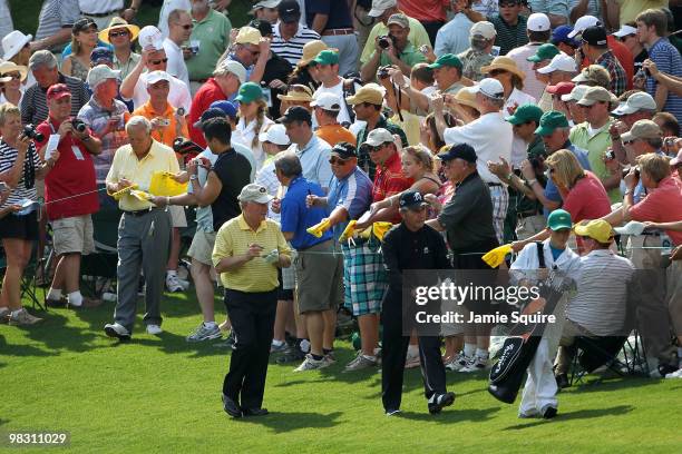 Arnold Palmer, Jack Nicklaus and Gary Player of South Africa walk together as they sign autographs for fans during the Par 3 Contest prior to the...