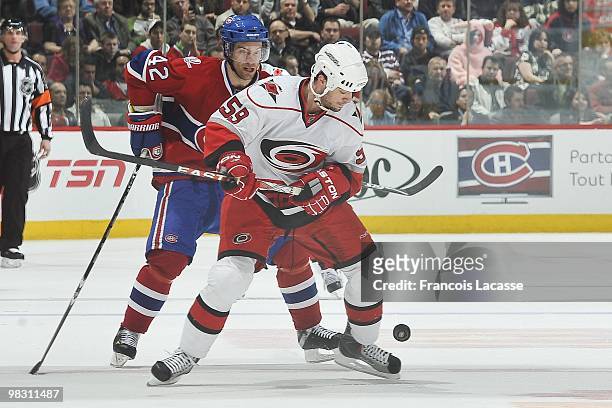 Chad LaRose of the Carolina Hurricanes skates with the puck on front of Dominic Moore of the Montreal Canadiens during the NHL game on March 31, 2010...