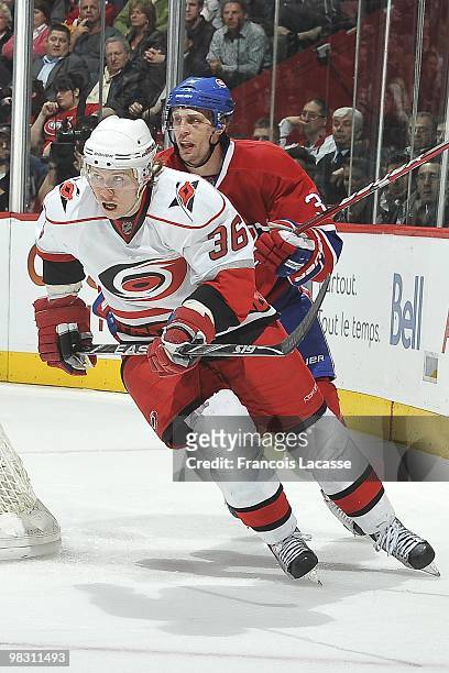 Jussi Jokinen of the Carolina Hurricanes skates for positions in front of Travis Moen of Montreal Canadiens during the NHL game on March 31, 2010 at...