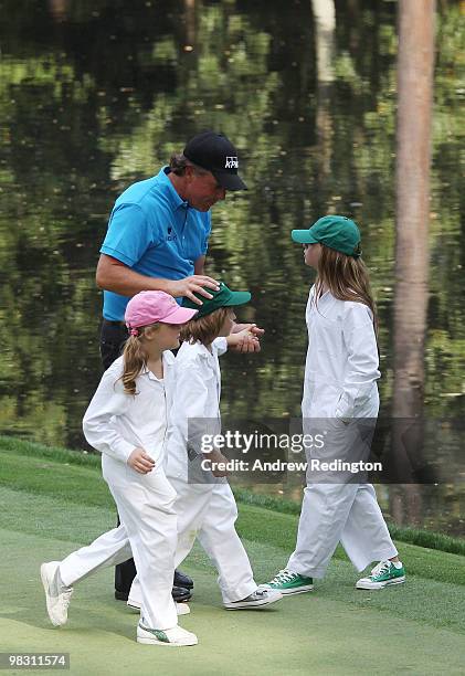 Phil Mickelson walks with his caddies/children Sophi, Evan and Amanda during the Par 3 Contest prior to the 2010 Masters Tournament at Augusta...