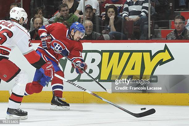 Tomas Plekanec of Montreal Canadiens takes a shot on front of Erik Cole of the Carolina Hurricanes during the NHL game on March 31, 2010 at the Bell...