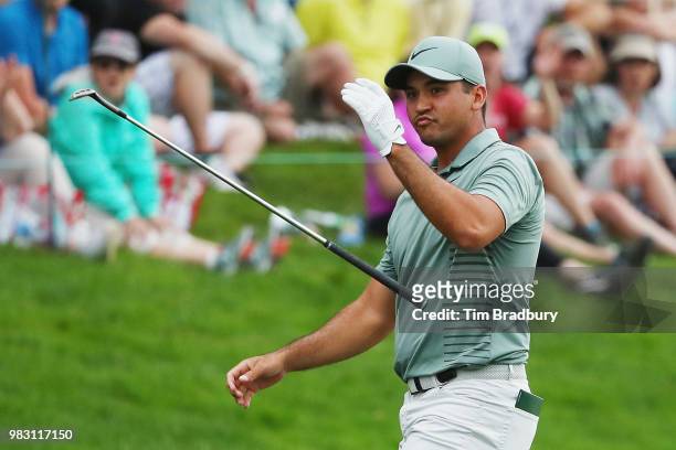 Jason Day of Australia tosses his club after chipping in for birdie on the 18th green during the final round of the Travelers Championship at TPC...