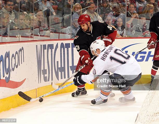 Adrian Aucoin of the Phoenix Coyotes fights for the puck with Shawn Horcoff of the Edmonton Oilers on April 3, 2010 at Jobing.com Arena in Glendale,...