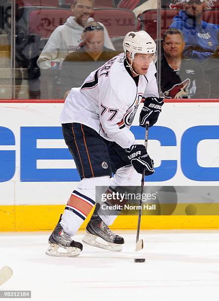 Tom Gilbert of the Edmonton Oilers skates with the puck against the Phoenix Coyotes on April 3, 2010 at Jobing.com Arena in Glendale, Arizona.