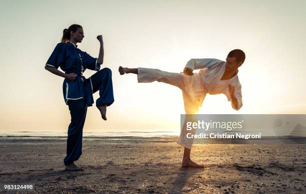 couple training in martial arts on the beach - sparring training - fotografias e filmes do acervo