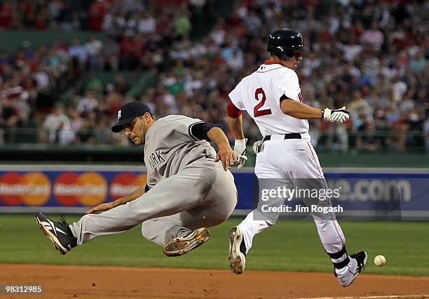 Andy Pettitte of the New York Yankees is tripped up covering first base as Jacoby Ellsbury of the Boston Red Sox reaches it safely in the first...