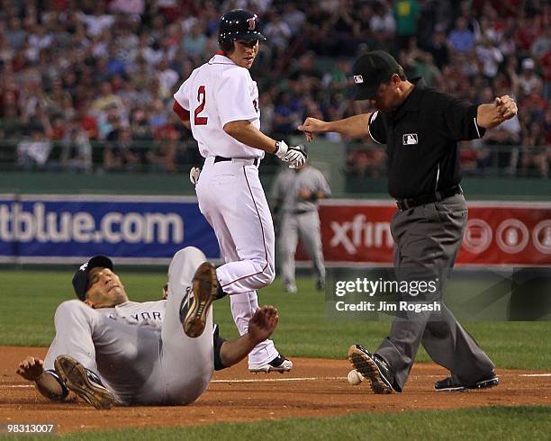 Andy Pettitte of the New York Yankees is tripped up covering first base as Jacoby Ellsbury of the Boston Red Sox reaches it safely in the first...