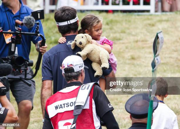 Bubba Watson leaves the course holding his daughter, Dakota, after making a putt for birdie on 18 and ultimately winning the Travelers Championship...