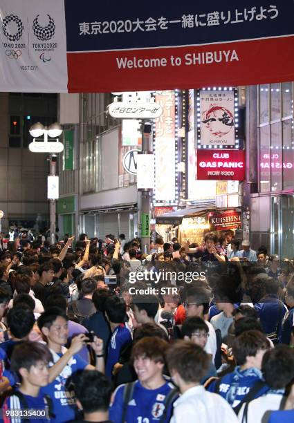 Supporters gather at Tokyo's Shibuya shopping district after watching the live broadcast of Japan's second World Cup football match in Group H...