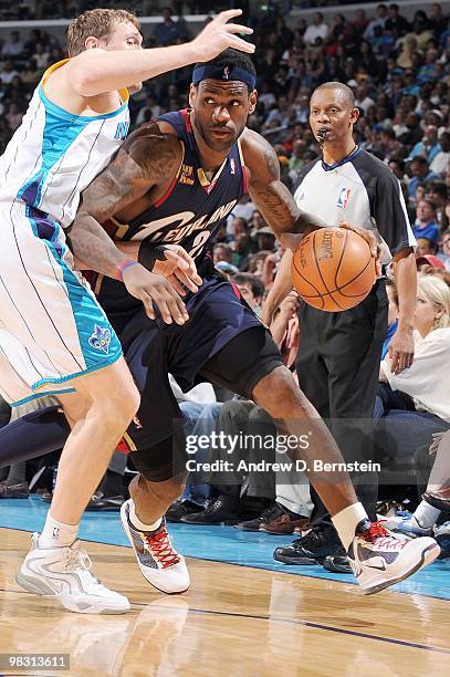 LeBron James of the Cleveland Cavaliers drives past Darius Songaila of the New Orleans Hornets during the game at the New Orleans Arena on March 24,...