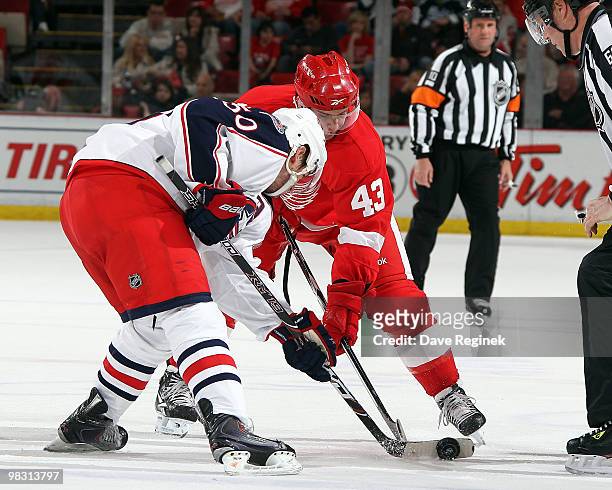 Antoine Vermette of the Columbus Blue Jackets and Darren Helm of the Detroit Red Wings face-off during an NHL game at Joe Louis Arena on April 7,...