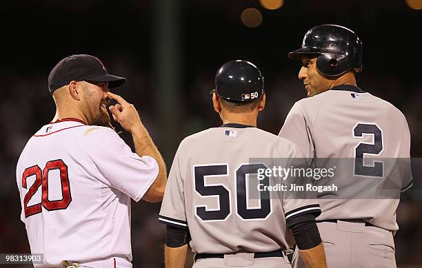 Kevin Youkilis of the Boston Red Sox laughs with Derek Jeter and first base coach Mick Kelleher of the New York Yankees after Jeter reached first...