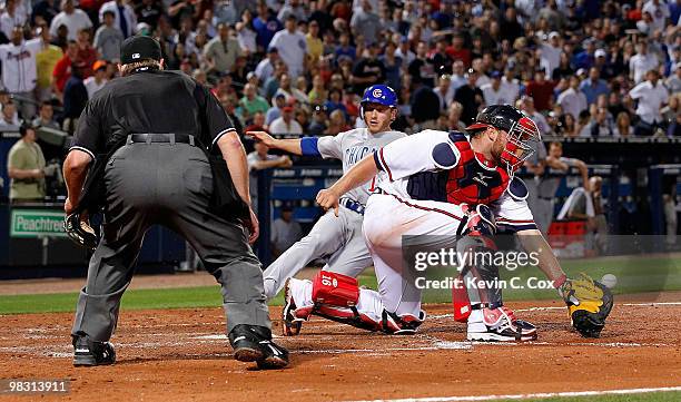 Catcher Brian McCann of the Atlanta Braves fails to catch the throw at home plate that allows Mike Fontenot of the Chicago Cubs to score at Turner...